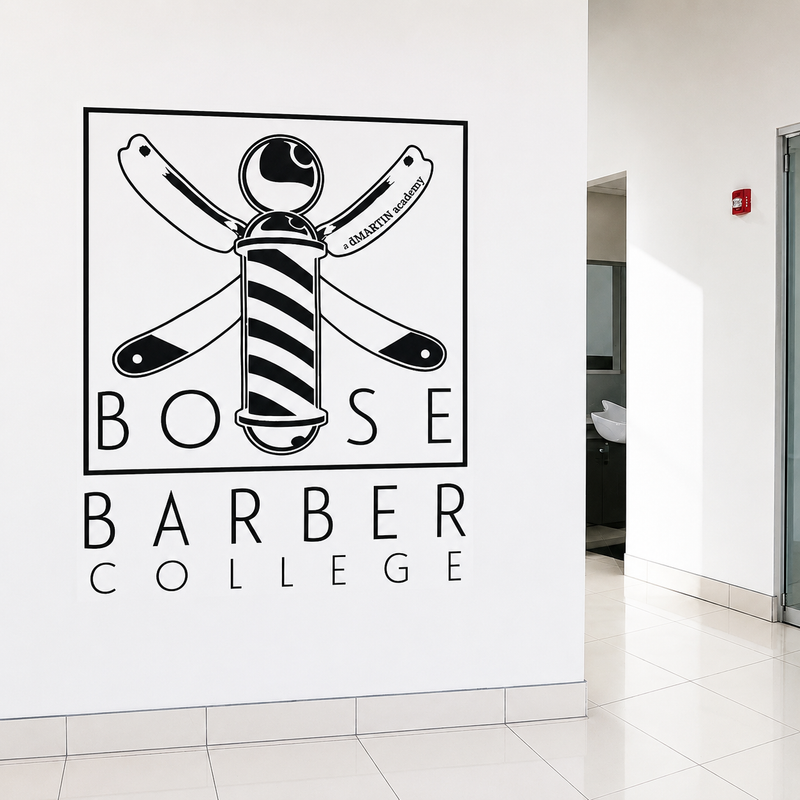 Boise Barber College wall graphic featuring a barber pole, crossed razors, and black lettering in a clean interior space.