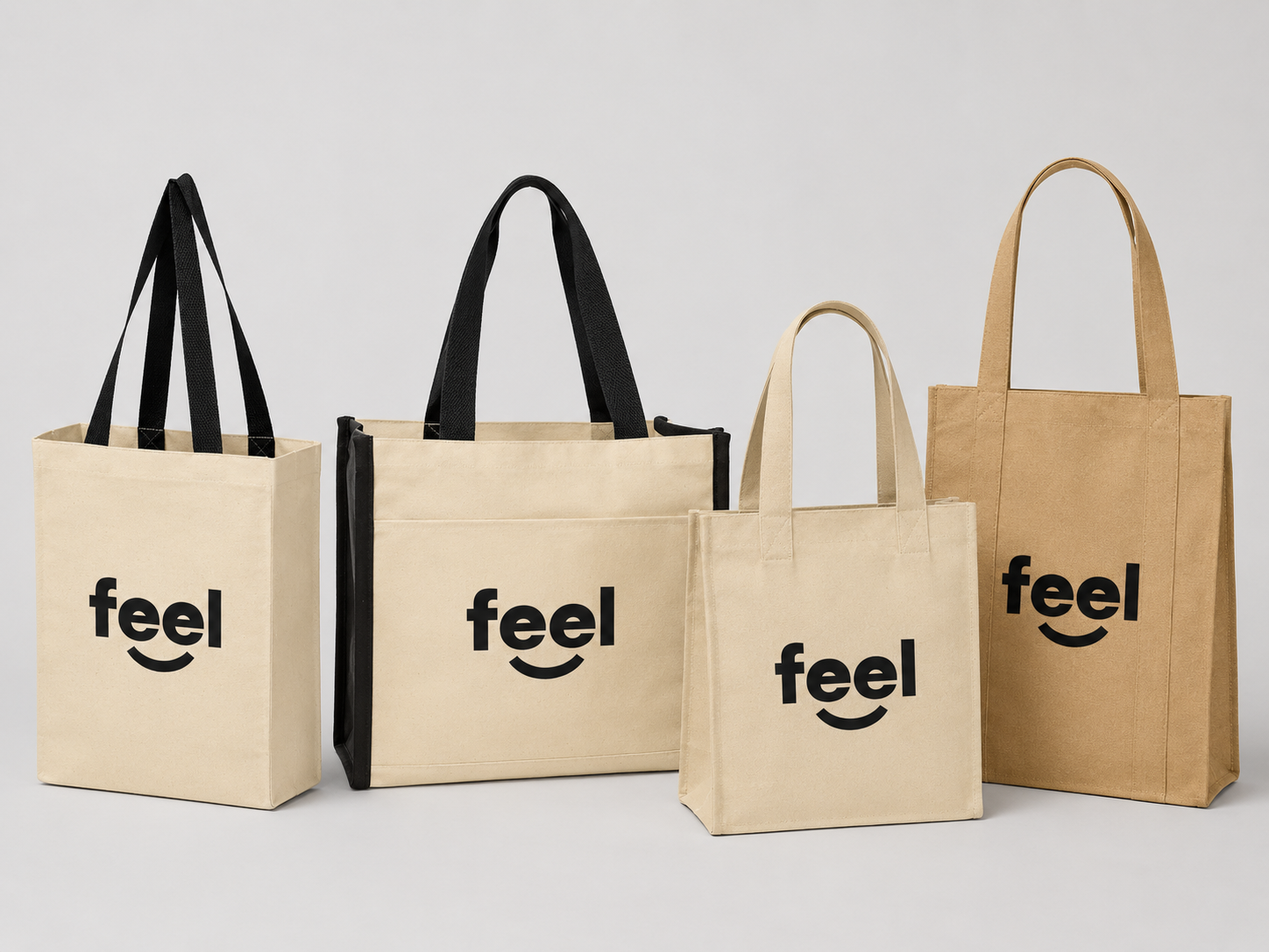 Custom tote bags with black Feel logo on natural canvas bags displayed together on a light gray background.