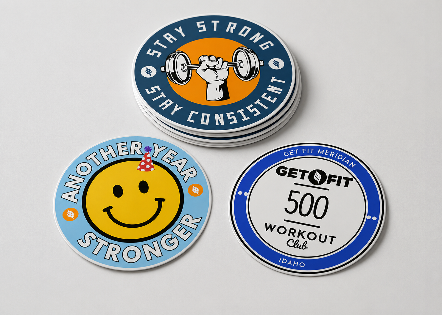 Custom circle stickers for fitness and event branding displayed on a light gray background, including Stay Strong, Another Year Stronger, and Get Fit Meridian designs.