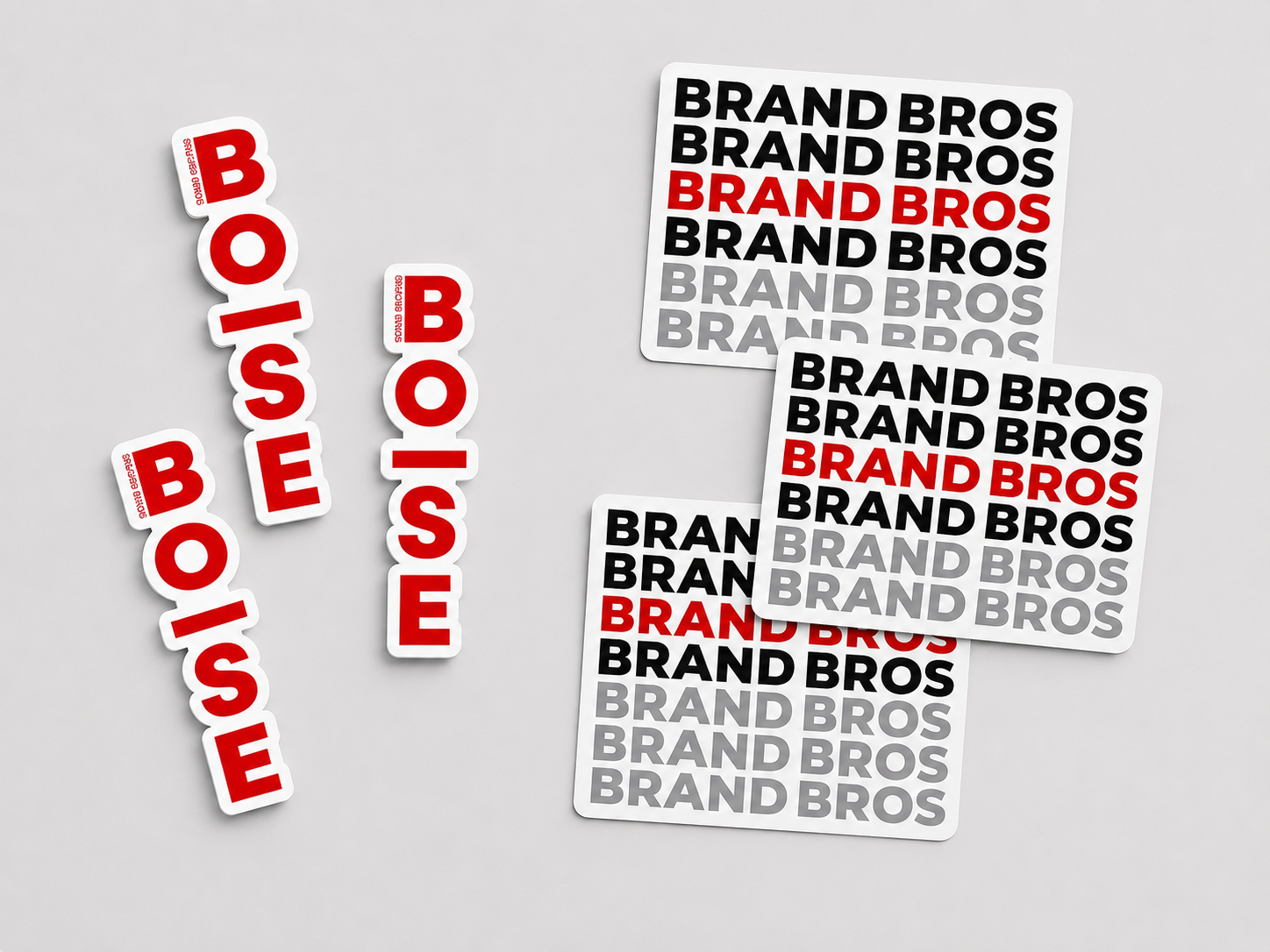 Custom Brand Bros Boise die-cut stickers and branded label sheets displayed on a light gray background as examples of sticker printing in Boise.