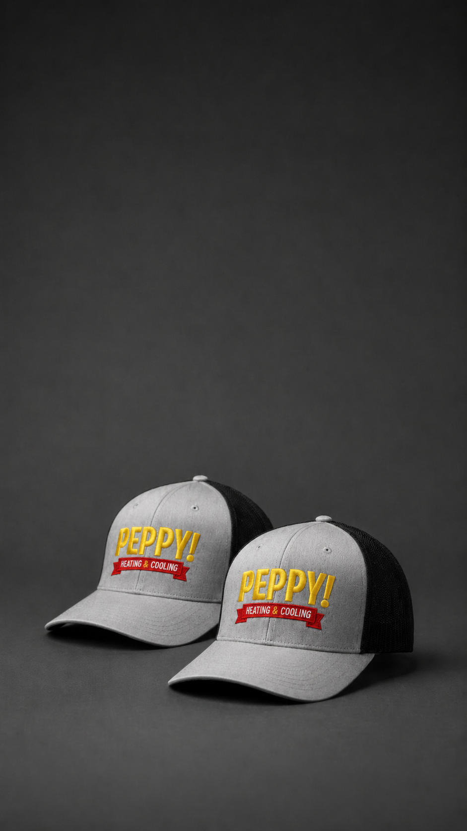 Custom embroidered Peppy Heating & Cooling gray and black trucker hats with yellow and red logo stitching for a Boise, Idaho company by Brand Bros Boise.
