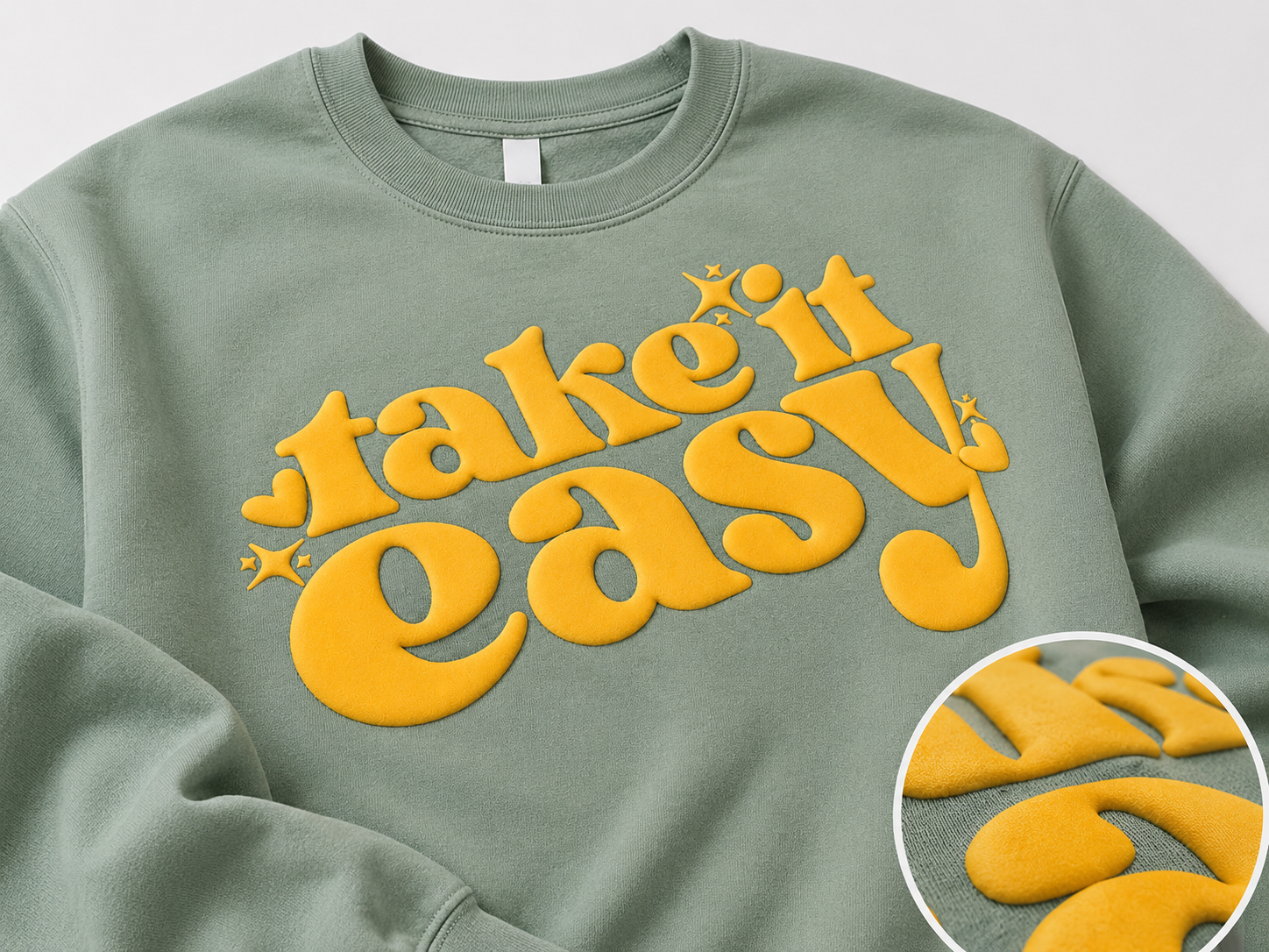 Sage green sweatshirt with raised yellow puff print lettering for custom textured apparel printing in Boise.